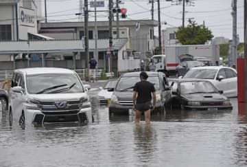 大雨で冠水した愛知県豊川市の道路で、水没した多くの車両＝6月3日