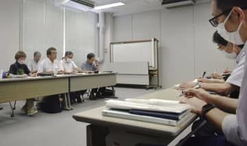 中国電力の担当者（右）と面会する、中間貯蔵施設建設計画に反対する市民団体のメンバー＝25日、広島市
