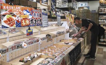 日本産の水産物も扱うスーパーで買い物をする客＝18日、香港（共同）