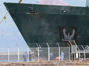 衝突事故を起こしたリベリア船籍のコンテナ船を調べる調査官ら＝26日午前、和歌山市
