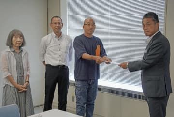 香川県に請願書を提出する「ActNow！！Kagawa」の名出真一代表（右から2人目）ら＝28日午前、高松市