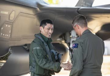 オーストラリア北部準州のティンダル空軍基地に到着し、出迎えを受ける航空自衛隊員（左）＝26日（オーストラリア国防省提供・共同）