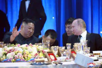 2019年、首脳会談後の夕食会で北朝鮮の金正恩氏（左）をもてなすロシアのプーチン大統領＝ウラジオストク（朝鮮中央通信＝共同）