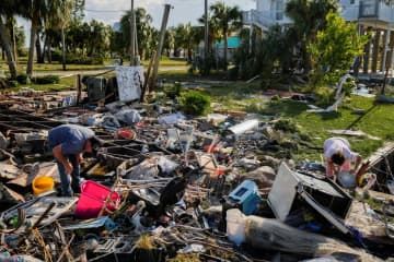 30日、ハリケーン「イダリア」が通過した米南部フロリダ州で、残骸となった自宅を調べる夫婦（ロイター＝共同）