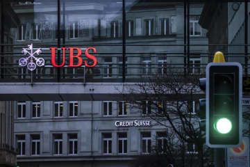 UBSとクレディ・スイスのロゴ＝3月、スイス・チューリヒ（AP＝共同）