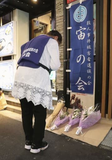 歌舞伎町ビル火災の現場近くで献花し、手を合わせる遺族の植田安子さん＝31日夜、東京都新宿区