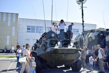 3日、北方領土の択捉島・紗那で、展示された軍車両を見学する人々（島民提供、共同）