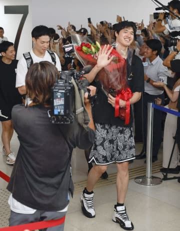 羽田空港に到着し、笑顔で手を振るバスケットボール男子日本代表の渡辺雄太（右）ら＝4日