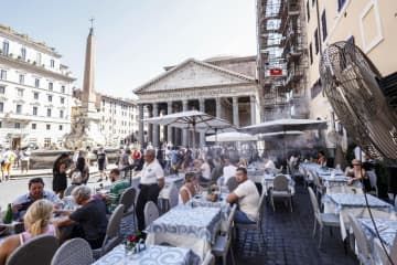 イタリア・ローマで、飲食店の客が屋外で涼を取るため設置された噴霧器＝8月19日（ゲッティ＝共同）