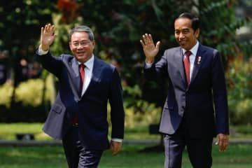 8日、インドネシア・ジャカルタで大統領宮殿の庭を歩くジョコ大統領（右）と中国の李強首相（ロイター＝共同）