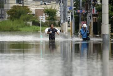 台風13号に伴う大雨の影響で冠水した道路を歩く人たち＝8日午後4時27分、千葉県茂原市