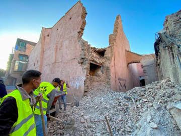 9日、地震で損壊した建物の前で作業する人ら＝モロッコ・マラケシュ（ロイター＝共同）