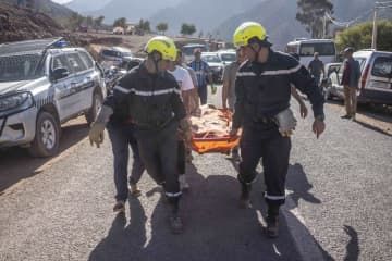 9日、地震の犠牲者を運ぶ救難チーム＝モロッコ中部マラケシュ付近（AP＝共同）
