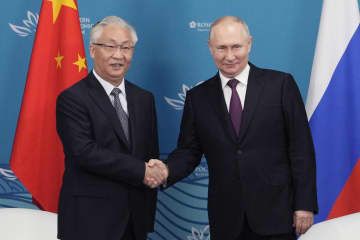 ロシアのプーチン大統領（右）と握手する中国の張国清副首相＝12日、ロシア・ウラジオストク（AP＝共同）
