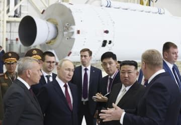 13日、ロシア極東アムール州のボストーチヌイ宇宙基地を視察するプーチン大統領（前列左から2人目）と金正恩朝鮮労働党総書記（同3人目）（AP＝共同）