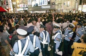 2005年、阪神がリーグ優勝し、大勢の警察官が厳戒するなか大阪・道頓堀に集まった人たち
