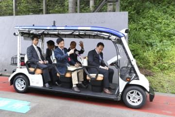 5月、「レベル4」の自動運転車両のデモ走行で、乗車する西村経産相（中央）ら＝福井県永平寺町