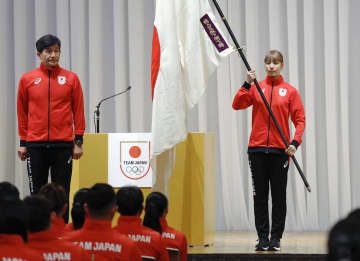 杭州アジア大会の日本選手団結団式で、尾県貢団長（左）から団旗を受け取ったフェンシング女子の江村美咲＝15日午後、東京都内のホテル