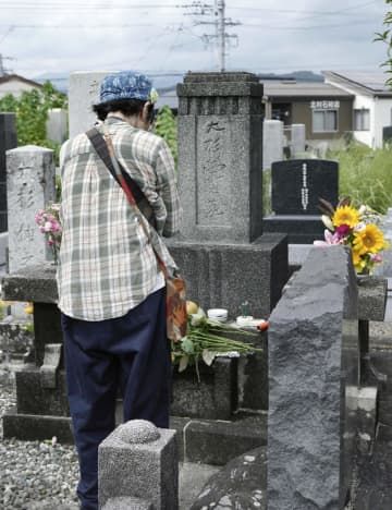 墓前祭が営まれた大杉栄の墓に献花し、手を合わせる参列者＝16日午前、静岡市