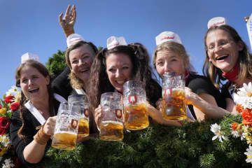 ビール祭り「オクトーバーフェスト」の会場でジョッキを手に写真に納まる女性ら＝16日、ドイツ・ミュンヘン（AP＝共同）
