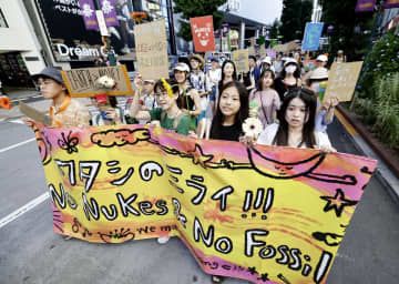 再エネ社会や脱原発を訴え、東京・渋谷の街頭をパレードする人たち＝18日午後