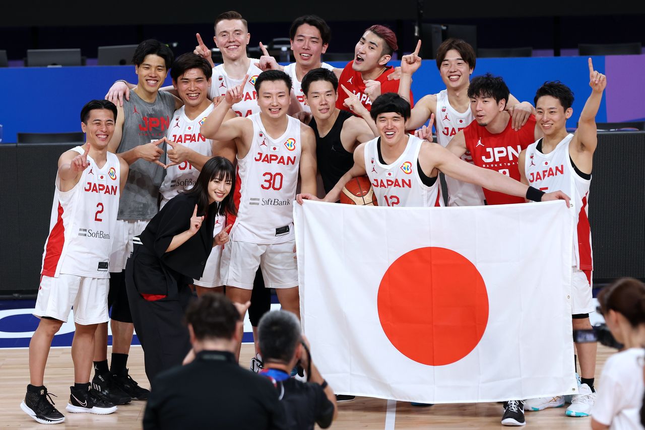カボベルデ戦に勝利してパリ五輪出場を決め、写真に納まる日本代表の選手たち=9月2日、沖縄アリーナ(時事)