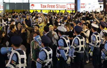 プロ野球阪神が日本シリーズ進出を決め、警察官が警備する中、大阪・道頓堀で盛り上がる人たち＝20日夜
