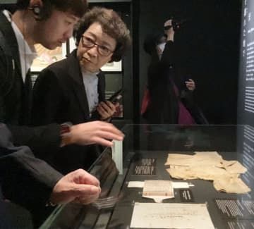 広島市の原爆資料館で説明を聞く李秀賢さんの母辛潤賛さん（左から2人目）＝21日午後