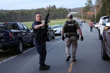 銃乱射事件を受け、巡回する警察官ら＝26日、米東部メーン州ルイストン近郊（ロイター＝共同）