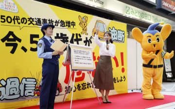 JR品川駅で開かれた交通安全イベントに参加する望月理恵さん（右）＝27日午前