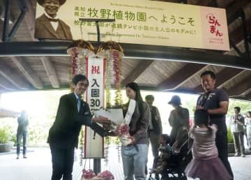 高知県立牧野植物園の2023年度入園者で30万人目となった兵庫県姫路市の奥住恵さん（左から2人目）＝27日午後、高知市