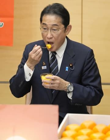 「奈良の柿PRレディ」から贈られた奈良県産の柿を試食する岸田首相＝1日午後、首相官邸