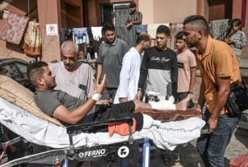 エジプト側への移送に向け、負傷者を救急車に運ぶ人ら＝1日、パレスチナ自治区ガザ南部ハンユニス（ゲッティ＝共同）