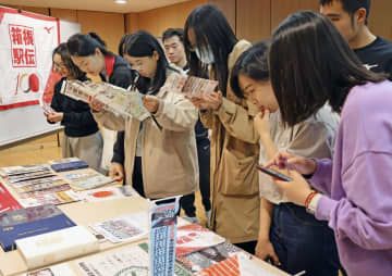 在中国日本大使館で箱根駅伝の資料を見るイベント参加者＝4日、北京（共同）