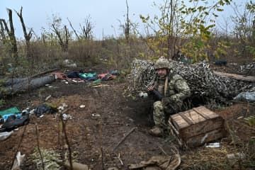 ウクライナ南部ザポロジエ州ロボティネ近くで、ロシア軍がいた場所を調べるウクライナ兵＝4日（ロイター＝共同）