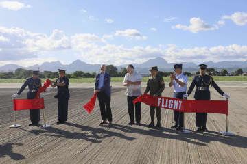 6日、フィリピン北部フロリダブランカのバサ空軍基地で、アスファルト舗装の更新を終えた滑走路に立つテオドロ国防相（右から4人目）や米当局者ら（共同）