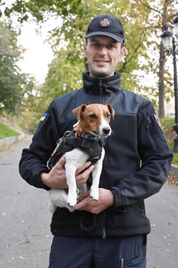 爆発物探知犬パトロンと飼い主のミハイロ・イリエフさん＝10月14日、キーウ（共同）
