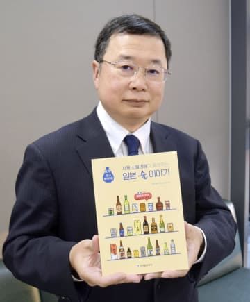 韓国で出版した書籍を手にする在韓日本大使館公報文化院の中條一夫前院長＝10月、ソウル（共同）