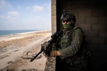 パレスチナ自治区ガザとされる場所で銃を持つイスラエル兵（イスラエル軍提供、ロイター＝共同）