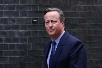 ロンドンの首相官邸近くを歩く英国のキャメロン元首相＝13日（ロイター＝共同）
