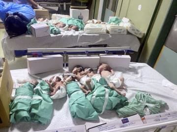 パレスチナ自治区ガザのシファ病院で、停電後に保育器からベッドに移された新生児＝12日（ロイター＝共同）