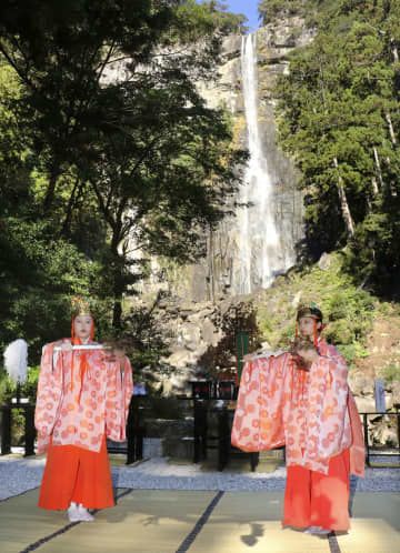 熊野那智大社のご神体「那智の滝」の前で舞を披露する巫女＝14日午前、和歌山県那智勝浦町