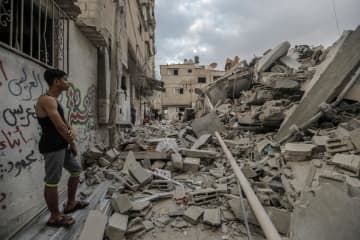 パレスチナ自治区ガザ南部ハンユニスで、イスラエルの攻撃により破壊された建物を捜索する人＝14日（ゲッティ＝共同）