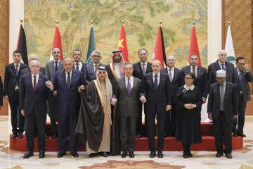 アラブ・イスラム諸国の閣僚級でつくる外交団と記念写真に納まる中国の王毅外相（前列中央）。同左端はパレスチナ自治政府のマルキ外相、同左から3人目はサウジアラビアのファイサル外相＝20日、北京の釣魚台迎賓館（共同）