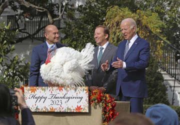 20日、ホワイトハウスで開かれた「七面鳥恩赦式」に出席するバイデン米大統領（右）（共同）