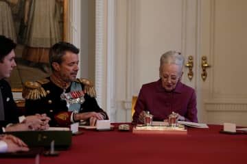 退位宣言に署名するデンマーク女王マルグレーテ2世（右）と、フレデリック皇太子＝14日、コペンハーゲン（ロイター＝共同）