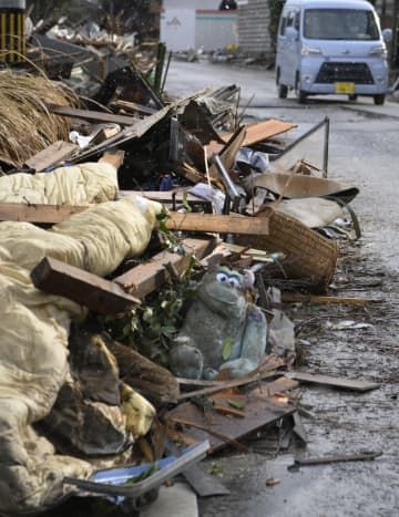 津波の被害を受けた石川県能登町の白丸地区。道路脇に寄せられたがれきの中に、ぬいぐるみもあった＝15日午前