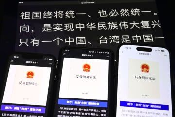 スマートフォンなどに表示された、中国国家安全省が「微信（ウィーチャット）」の公式アカウントに投稿した反国家分裂法の解説。「祖国を必ず統一する」などと書かれている（共同）