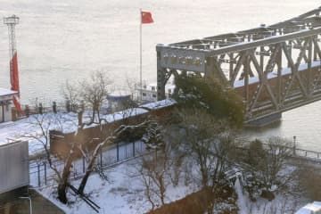 「中朝友誼橋」を渡って北朝鮮へ向かう貨物列車＝2022年12月、中国遼寧省丹東（共同）