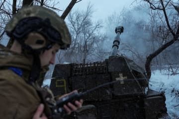 ウクライナ東部ドネツク州バフムト近郊で、ロシア軍に向けてりゅう弾砲を発射するウクライナ軍兵士＝16日（ロイター＝共同）